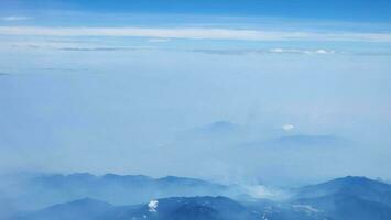 bleu ciel et blanc des nuages comme vu par fenêtre de un avion. photo