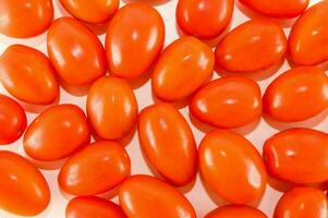 une groupe de rouge tomates sur une blanc surface photo