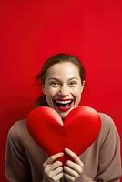 portrait de une content femme avec rouge cœur sur une rouge background.valentine's journée concept ai généré photo