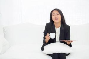 jeune femme d'affaires asiatique assise sur un canapé à la maison. photo
