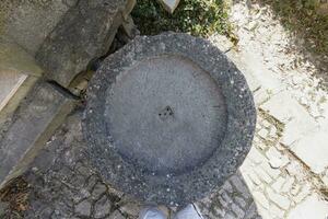 Haut vue de un vieux pierre lavabo plus de une pavé sol photo