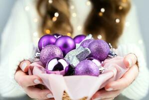 aux femmes mains tenir une panier avec Noël décorations. fermer. sélectif se concentrer. photo