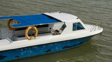petit passager moteur bateau avec personne à l'intérieur amarrage, parking ou flottant dans le l'eau. photo