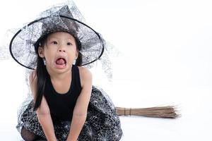 Portrait petite fille asiatique s'habiller en sorcière isolé sur écran blanc photo