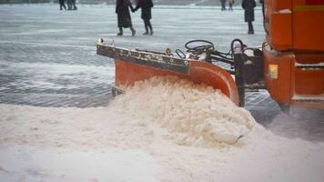 le tracteur nettoie le chaussée dans l'hiver. tracteur nettoyage le route de le neige. excavatrice nettoie le des rues de grand les montants de neige dans ville. une seau fermer nettoie le trottoir de neige. photo
