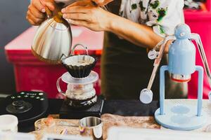 professionnel barista en train de préparer café en utilisant chemex verser plus de café fabricant et goutte bouilloire. photo