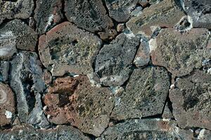 une pierre mur avec beaucoup différent les types de rochers photo