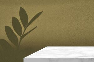 blanc marbre table coin avec zanzibar gemme feuilles ombre sur le beige béton mur arrière-plan, adapté pour produit présentation toile de fond, afficher, et moquer en haut. photo