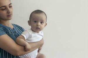 mère et bébé. maman en portant sa 6 mois bébé garçon. magnifique bébé garçon de six mois dans le sien de la mère mains. Jeune milieu est mère en portant dans sa bras sa peu fils photo