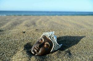 une visage sculpture dans le le sable photo