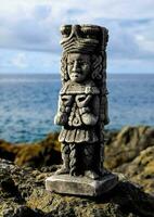 une pierre statue de une homme permanent sur une Roche photo