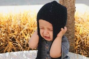 malheureux 2-3 ans vieux enfant pleurs dans l'automne jardin photo