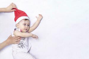 peu Père Noël. 1 an bébé fille dans Père Noël claus chapeau. joyeux Noël. adorable moyen-orient fille dans Père Noël casquette. photo