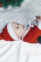 peu Père Noël. 6-9 mois vieux bébé garçon dans Père Noël claus costume. joyeux Noël photo