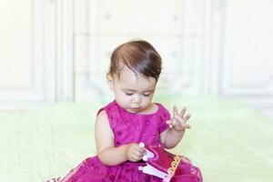 premier anniversaire. peu de bonne humeur bébé fille avec couronne célébrer sa premier anniversaire fête photo