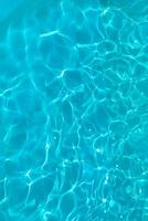 Azur transparent texture de l'eau dans une bleu bassin avec éclaboussures de le Soleil photo