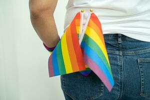 femme en portant lgbt arc en ciel coloré drapeau, symbole de lesbienne, gay, bisexuel, transgenres, Humain droits, tolérance et paix. photo