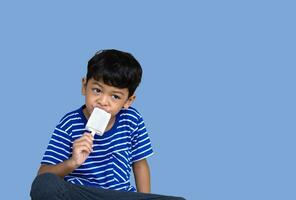 peu thaïlandais garçon en mangeant blanc Chocolat la glace crème photo