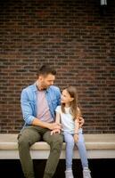 père et le sien fille avoir une bien temps dans de face de maison porte photo