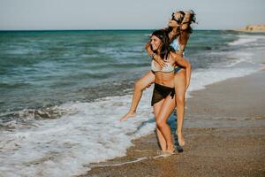 deux jolie Jeune femme ayant amusement sur le bord de mer photo