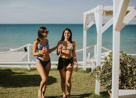 souriant Jeune femmes dans bikini profiter vacances sur le plage photo