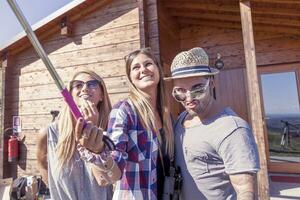 groupe de souriant copains prise marrant selfie avec intelligent téléphone photo