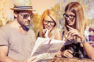 groupe de Jeune randonneurs chercher sur le carte le droite façon photo