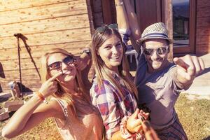 groupe de souriant copains prise marrant selfie avec intelligent téléphone photo