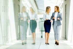 deux Jeune affaires femmes en marchant et discuter dans le Bureau couloir photo