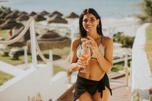souriant Jeune femme dans bikini profiter vacances sur le plage photo