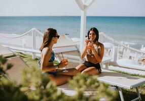 souriant Jeune femmes dans bikini profiter vacances sur le plage photo