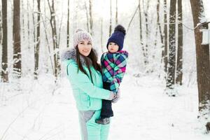 famille heureuse mère et enfant bébé fille sur une promenade d'hiver dans les bois photo