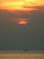 le coucher du soleil et solitaire bateau à Thaïlande mer photo
