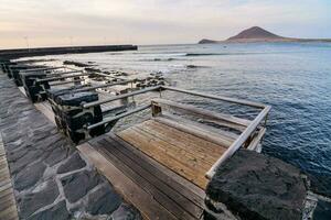 une en bois passerelle pistes à le océan à le coucher du soleil photo