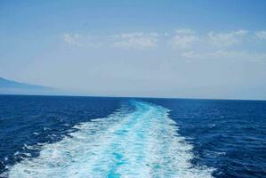 le réveiller de une bateau en voyageant à travers le océan photo