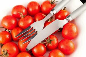 une couteau et fourchette sont séance sur une assiette de tomates photo