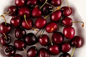 une bol de cerises sur une blanc surface photo