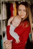 une mère détient une en train de dormir enfant dans sa mains. maman câlins le bébé. photo