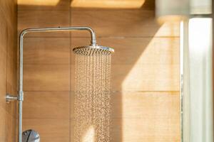 pommeau de douche extérieur pour le bain et douche d'eau froide sur le corps avant de sauter dans la piscine du complexe. photo