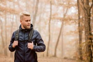 une homme voyages dans une brumeux l'automne forêt photo