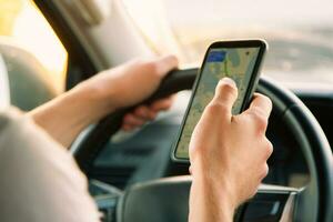 une touristique est séance dans une voiture et à la recherche pour le route dans le navigateur app sur une ensoleillé journée photo