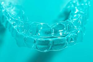 invisible dentaire les dents supports dent aligneurs sur bleu Contexte. Plastique un appareil dentaire dentisterie retenues à redresser dents. photo