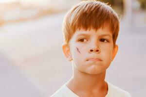portrait de une mignonne garçon avec une cicatrice sur le sien visage photo