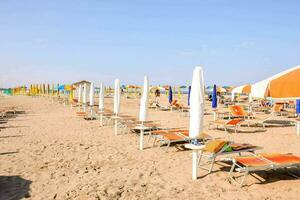 beaucoup plage chaises et parapluies sur le le sable photo