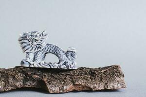 céramique dragon sur arbre écorce sur gris Contexte pour chinois Nouveau année photo