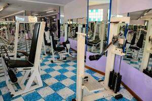 une Gym pièce avec une miroir et poids photo