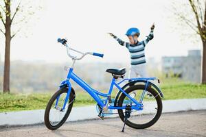 mignonne enfant dans casque et protection des stands près le sien bicyclette photo