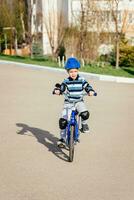 une enfant dans une casque et protection dans une bicyclette balade sur la nature dans le printemps photo