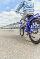 une enfant dans une casque et protection dans une bicyclette balade sur la nature dans le printemps photo