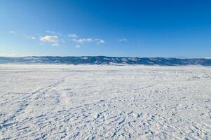 vue de congelé Lac Baïkal dans hiver saison, le surface de Lac couvert par neige. Lac Baïkal est le du monde le plus profond Lac situé dans du sud Sibérie, Russie. photo